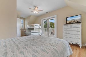 a bedroom with a bed and a dresser and a window at A 4 Bedroom House in Gated Litchfield By the Sea in Pawleys Island