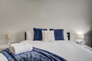 a bedroom with a large white bed with blue pillows at Rustic Outlaw Secluded Escape with Stunning Views in Cripple Creek