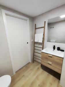 a bathroom with a sink and a mirror and a ladder at Apartmento Río Turia Caracol in Valencia