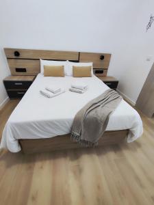 a bedroom with a large bed with two towels on it at Apartmento Río Turia Caracol in Valencia