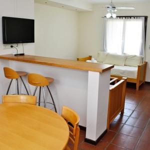 ein Wohnzimmer mit einer Bar mit einem Tisch und Stühlen in der Unterkunft De la Plaza Hotel y Apart in Villa Gesell