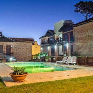 ein Swimmingpool vor einem Haus in der Unterkunft De la Plaza Hotel y Apart in Villa Gesell