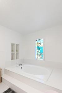 a white bathroom with a sink and a window at Hueytown Haven nearby Alabama Splash Adventure in Bessemer +33 photos