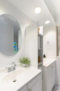 a white bathroom with a sink and a mirror at Hueytown Haven nearby Alabama Splash Adventure in Bessemer