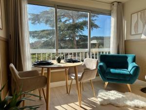 a dining room with a table and chairs and a large window at La Pinède Bleue in Saint-Mandrier-sur-Mer