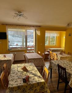 a dining room with tables and chairs and a room with tables and chairsktop at Zakątek Pensjonat in Wisła