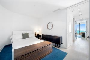Dormitorio blanco con cama grande y alfombra azul en Ocean View Residence at South Beach -1614, en Miami Beach