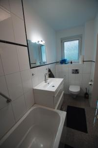 a bathroom with a tub and a sink and a toilet at Modern house half - near Hamburg Airport in Norderstedt +9 photos