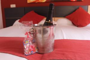 Una botella de vino en un cubo en una cama en Hostal Falfes, en Madrid