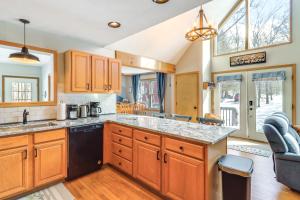 a kitchen with wooden cabinets and a counter top at 7 Mi to Big Boulder Mtn Poconos Chalet with Hot Tub in Albrightsville