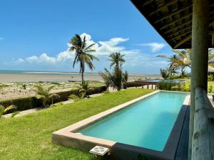 ein Swimmingpool mit Blick auf den Strand in der Unterkunft Casa do vento - Ilha do Guajiru in Itarema