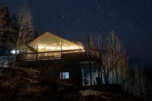 a house with lights on the side of it at night at Sunset Mountain Views near Town on 3 Private Acres in Bailey +75 photos