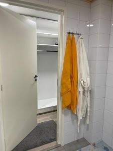 a bathroom with an open door with towels hanging at Modern furnished studio in Martinkylä