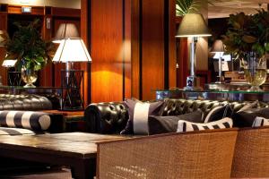 a living room with a leather couch and a table at Hotel 1898 in Barcelona