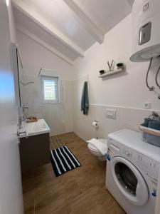 a bathroom with a washing machine and a toilet at Guest House Lena, Nerezine, Mali Losinj in Nerezine