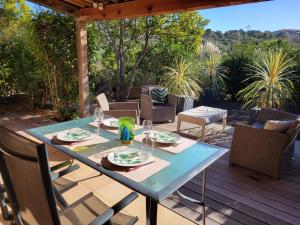 a table with plates and glasses on a patio at Mini villa proche plage Santa Giulia in Porto-Vecchio