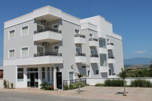 - un bâtiment blanc avec balcon dans une rue dans l'établissement Hotel Água Viva - Cachoeira Paulista - SP - Próximo a Canção Nova, à Cachoeira Paulista