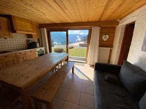 a wooden table in a kitchen with a large window at Chalet Fleur des Alpes 1 in Les Gets
