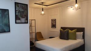 Ga-MothapoにあるVilla Tlhago Lodgeのベッドと壁に2つのライトがある寝室 +20枚の写真