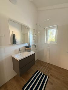 a bathroom with a sink and a shower at Guest House Lena, Nerezine, Mali Losinj in Nerezine +40 photos
