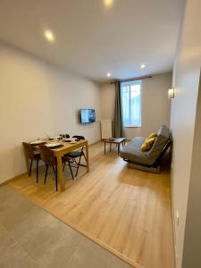 un soggiorno con un tavolo e una sala da pranzo di Appart'Village Le vieux Vichy centre T1,T2,T3 - Parking - Thermes a Vichy
