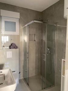 a shower with a glass door in a bathroom at Apartment Loft 22 in Mostar