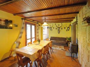 a dining room with a long table and a couch at holiday home with thatched roof, Rekowo in Rekowo