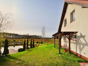 ein Haus mit einem Rasenplatz neben einem See in der Unterkunft Holiday apartment, 2 bedrooms, garden, bicycles in Radzikowo