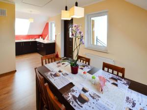ein Esstisch mit einer Vase mit Blumen darauf in der Unterkunft Holiday apartment, 2 bedrooms, garden, bicycles in Radzikowo + 20 Fotos