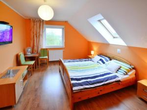 ein Schlafzimmer mit einem Bett, einem Schreibtisch und einem Fernseher in der Unterkunft Holiday apartment, 2 bedrooms, garden, bicycles in Radzikowo