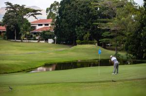 Un uomo sta giocando a golf su un campo da golf di Exclusive Suite at Playa Coronado Luxury Club a Playa Coronado Altre 2 foto