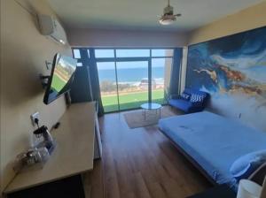 拉莫西La vue bella Oceans rest的一间客房内配有床和电视的房间