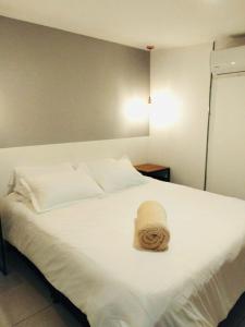 a white bed with a towel on top of it at Urban Oasis Med in Medellín