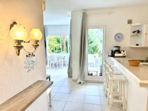 a kitchen with a counter and a table with chairs at Casa Lilo, en jardin grande, con una gran piscina y barbacoa in Arona