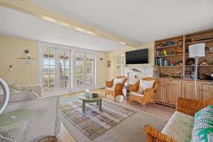 a living room with a couch and chairs and a tv at Oyster Catcher - Pet friendly & deep water access! in Deep Hole