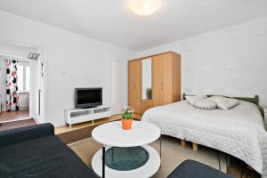 a white bedroom with a bed and a table at Majoitushuoneisto Tuomipuisto in Naantali