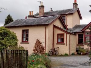 a house with a bicycle parked in front of it at Strathpeffer Holiday Cottages in Strathpeffer +10 photos
