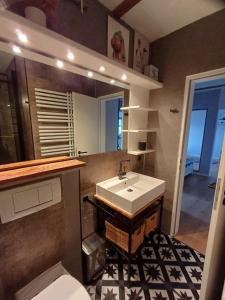 a bathroom with a sink and a toilet and a mirror at Moewennest-by-DeJu-Norderney in Norderney +39 photos