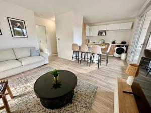 a living room with a couch and a table at Petit havre de paix ! in Carcans