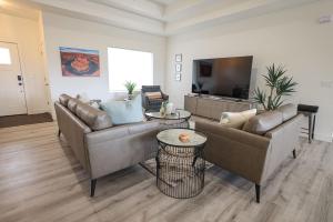 a living room with two couches and a flat screen tv at Brand New Home with Private Pool and Hot Tub in Kanab +19 photos