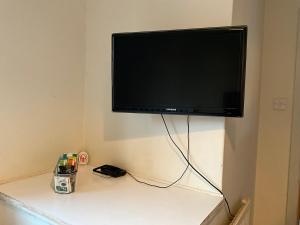 a flat screen tv hanging on a wall at Private Rooms with Shared Bathroom Bus Stop 8 Mins Away in Earley