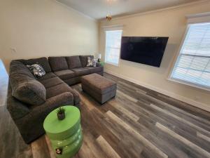 a living room with a couch and a flat screen tv at Sunny Retreat-Near Beach-Pickleball-Heated Pool! in Fort Myers Beach