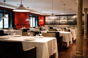 a restaurant with white tables and chairs and lights at Hotel 1898 in Barcelona