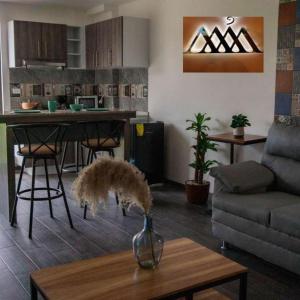 ein Wohnzimmer mit einer Vase auf einem Couchtisch in der Unterkunft Hotel entre volcanes in Cholula de Rivadavia