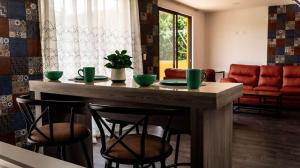 ein Esszimmer mit einem Tisch und Stühlen mit grünen Tassen in der Unterkunft Hotel entre volcanes in Cholula de Rivadavia