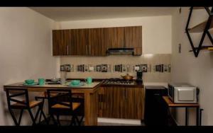 eine Küche mit einem Tisch, Stühlen und einer Mikrowelle in der Unterkunft Hotel entre volcanes in Cholula de Rivadavia