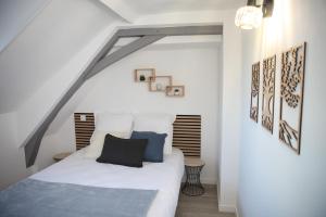 a bedroom with a white bed with blue pillows at L'Attique, confort, aéré, centre-ville, Netflix in Laval