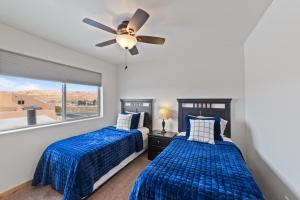 2 camas en un dormitorio con ventilador de techo en Steel Bender Villa, en Moab 23 fotos más