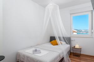 a white bedroom with a bed and a window at Apartmani Marko in Trogir +22 photos