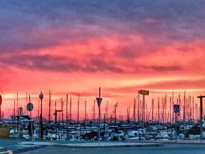 a group of boats parked in a marina at sunset at Puerto Pollensa peaceful apartment, mountain views in Port de Pollensa